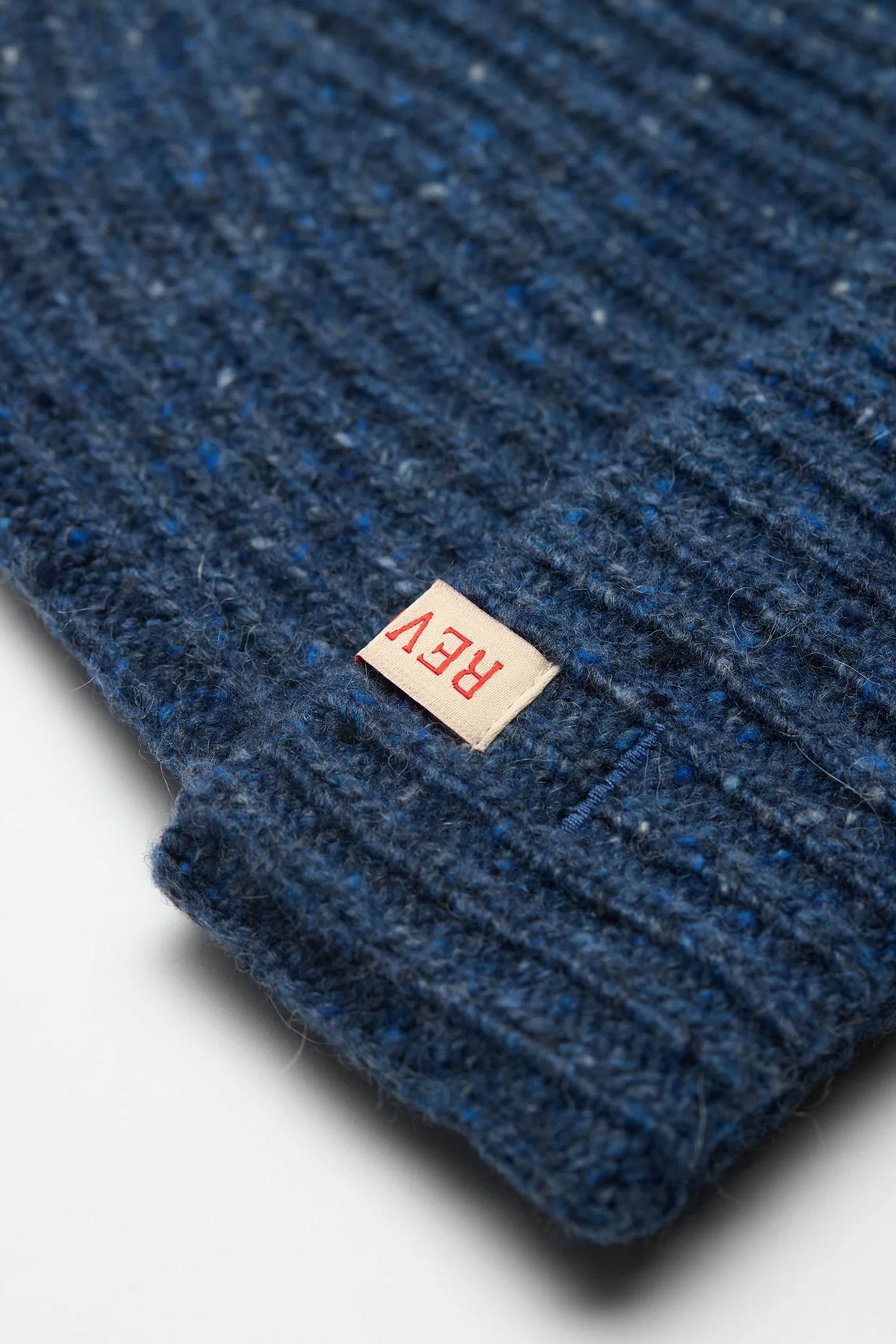 Close-up of Revolution blue textured beanie with a red 'REV' label Happylifeshops