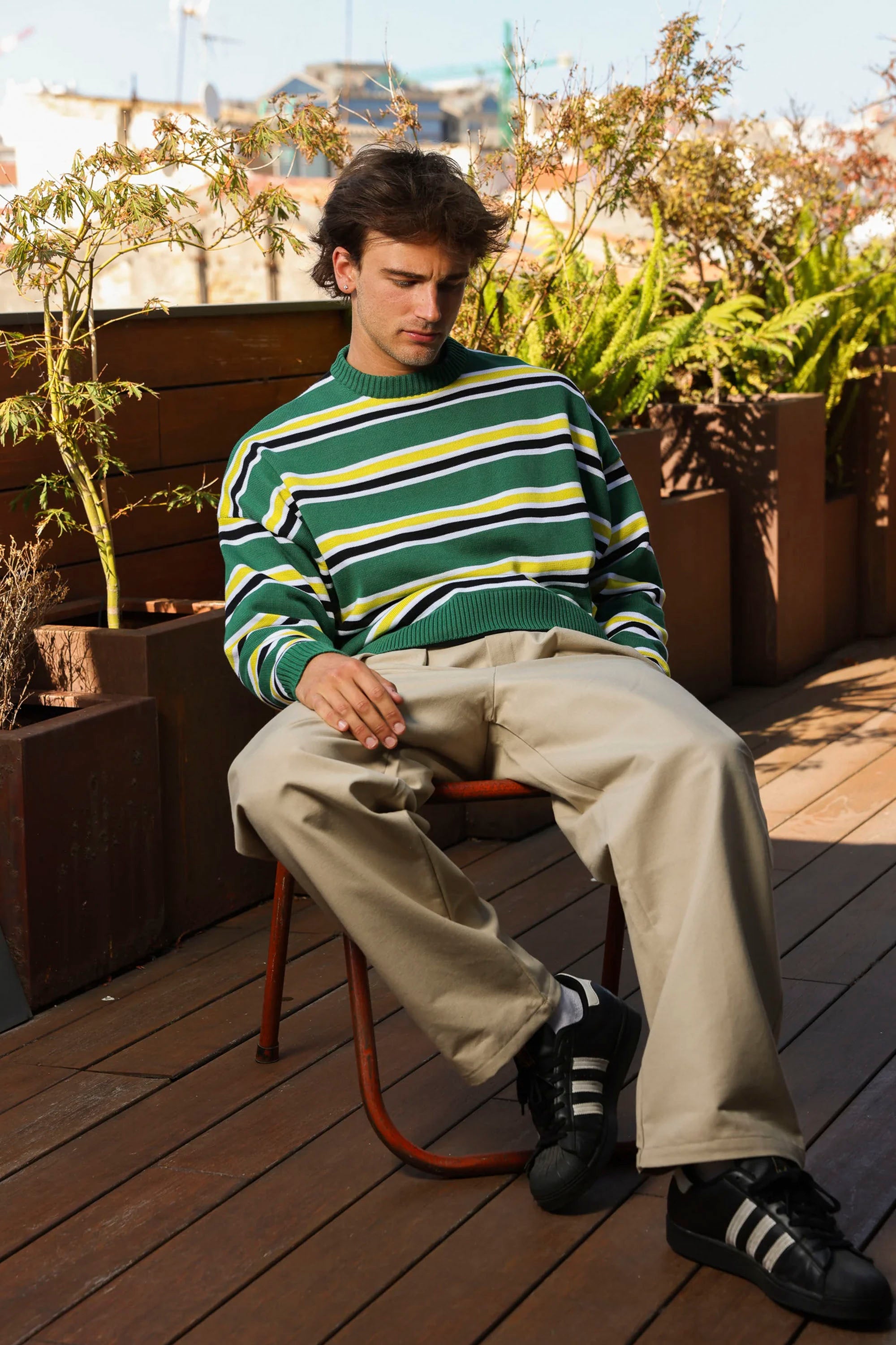 Man sitting on a chair with Nowhere striped sweater Happylifeshops