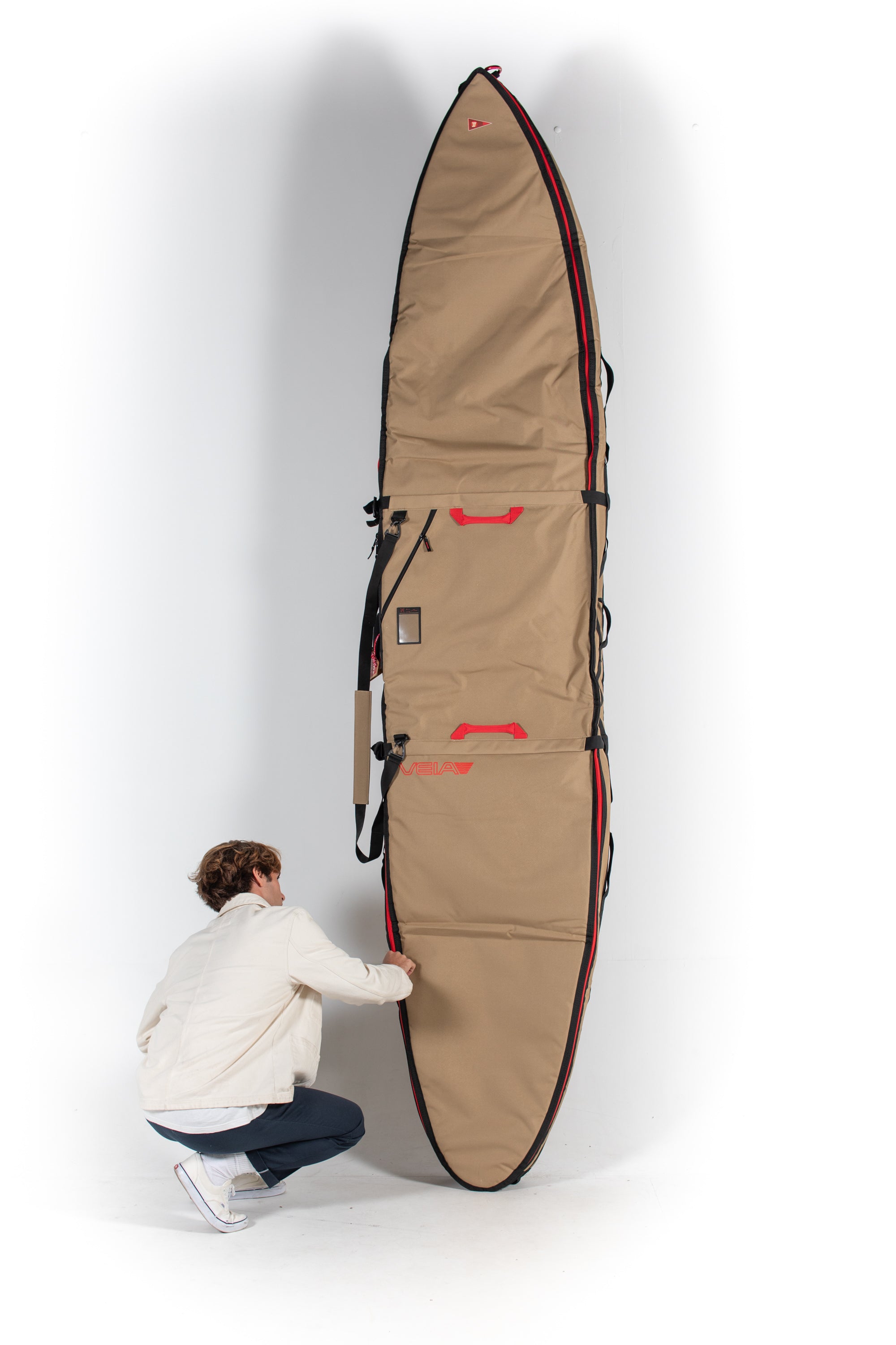 Happylifeshops Veia Supplies Person holding a large beige surfboard bag against a white background